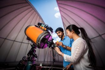 Two students using a telescope