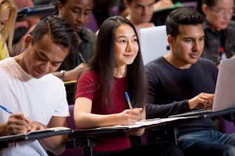 Students with laptops in lecture theatre class