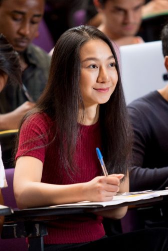 Students with laptops in lecture theatre class