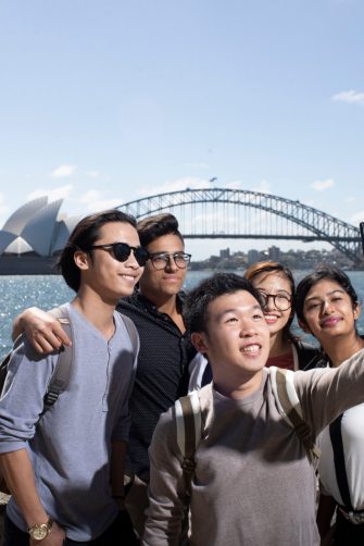 Students taking selfie in front of Sydney Opera House and Harbour Bridge