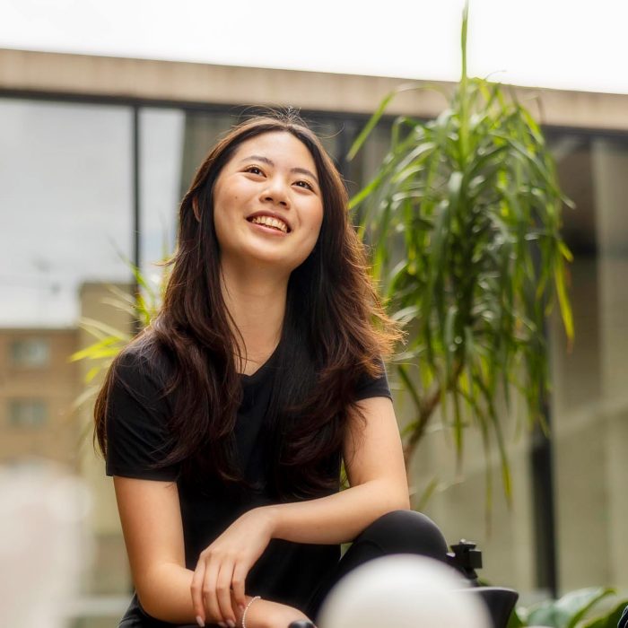 Student in courtyard, smiling, looking to the future