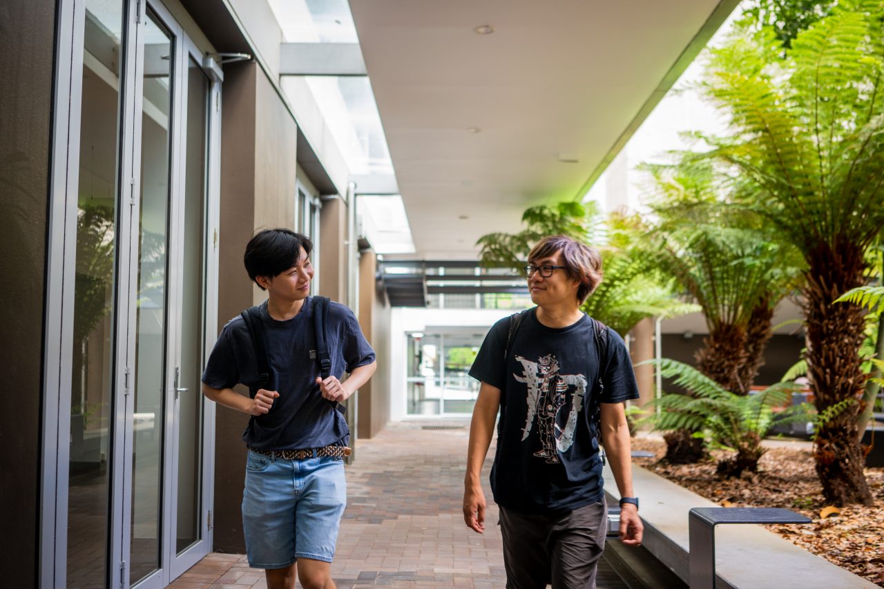 Two students smiling while walking on Kensington Campus