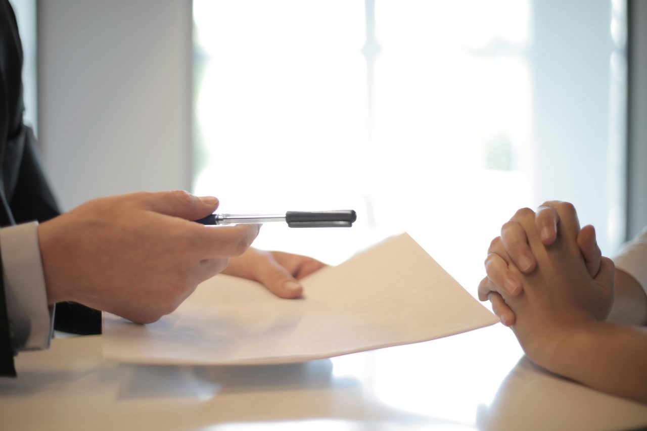 Hands across table, discussing document